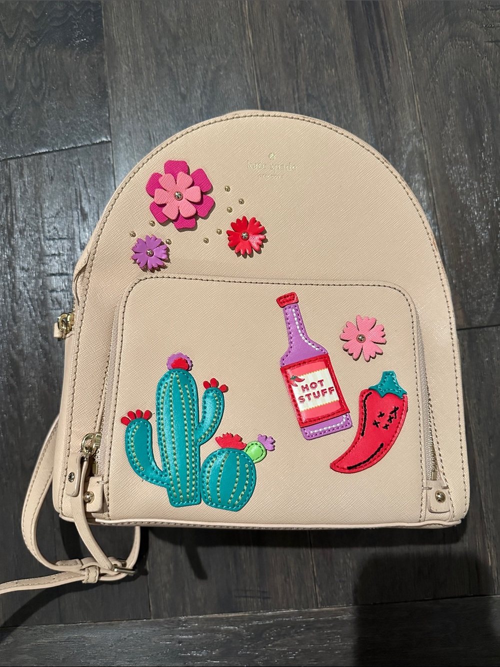 kate spade beige backpack with colorful cactus, chili and floral appliqués